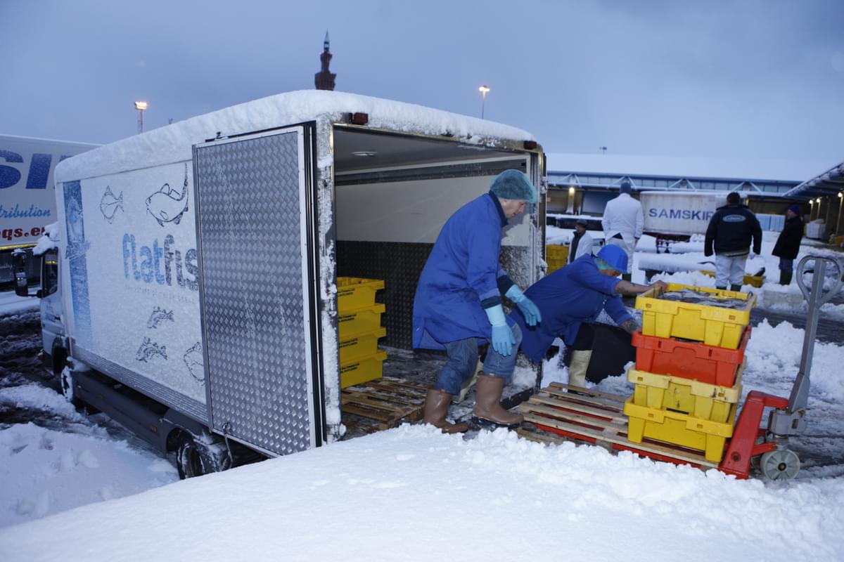 Loading pallets of fishboxes into a lorry - snow on the ground