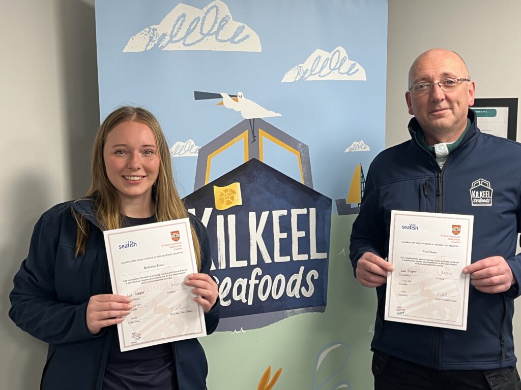 Two people stood holding training certificates